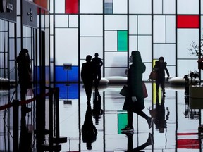 People wearing face masks walk inside an office building at the Lujiazui financial district in Pudong, Shanghai, China on Feb. 10, 2020. (REUTERS/Aly Song)