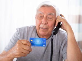 Man With Credit Card Using Landline Phone