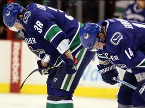 Victor Oreskovich (left) and Alex Burrows  of the Vancouver Canucks react after being defeated by the Boston Bruins in Game Seven of the 2011 NHL Stanley Cup Final at Rogers Arena in Vancouver on June 15, 2011 . (ELSA/Getty Images files)