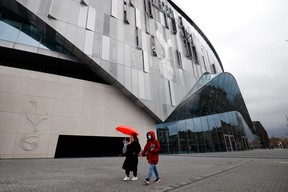 A woman wearing a protective face mask walks near the Tottenham Hotspur Stadium in London, on March 15, 2020, as the English Premier League football match between Tottenham Hotspur and Manchester United was postponed due to the COVID-19. (GETTY IMAGES)