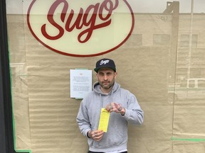 Sugo restaurant owner Conor Joerin holds the ticket that prompted Toronto parking officers to tow his van from outside of his Bloor St. West eatery while loading food intended for donation on Monday. He wants city parking officers to give local residents and business owners a break.