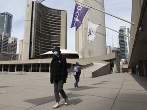 Pedestrians pass through Nathan Phillips Square in front of Toronto City Hall.
