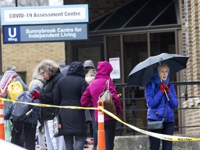 People wait in line to enter the COVID-19 Assessment Centre  at Sunnybrook Hospital in Toronto on March 17, 2020.