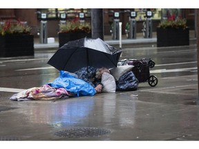 A homeless person shelters on a street in Toronto on March 29, 2020.