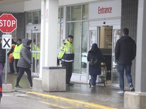 Shoppers practice safe distancing outside a Metro grocery store at Danforth and Victoria Park. Aves.  in Toronto on March 23, 2020. Jack Boland/Toronto Sun