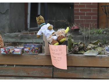 Some stuffed toys, board games, DVDs and books sit along a front of a home offering them up for free to pedestrians with the sign "Need a Friend? Take one Home! on Thursday March 26, 2020. Jack Boland/Toronto Sun/Postmedia Network