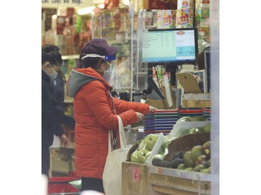 Business as usual at curbside stores and fresh produce markets along Spadina Ave. in the Chinatown area  on Thursday March 26, 2020. Jack Boland/Toronto Sun/Postmedia Network