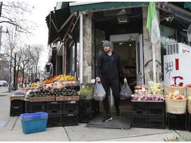 Mark Sikorski exits the Fresh Fruit Market grocery and plant store along curbside markets on College St. W. and Montrose Ave.  in the Little Italy areaon Thursday March 26, 2020. Jack Boland/Toronto Sun/Postmedia Network