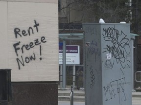 Sign of the times graffiti on the outside walls of a bank at Spadina Ave and College St. W. exclaims "Rent Freeze Now!" on Thursday March 26, 2020. Jack Boland/Toronto Sun/Postmedia Network