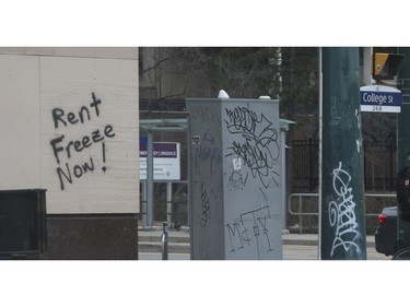 Sign of the times graffiti on the outside walls of a bank at Spadina Ave and College St. W. exclaims "Rent Freeze Now!" on Thursday March 26, 2020. Jack Boland/Toronto Sun/Postmedia Network