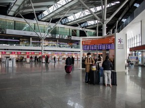 Passengers wearing face masks are seen at the terminal of Warsaw Chopin Airport following an outbreak of coronavirus in Warsaw, Poland, on Friday, March 13, 2020.