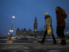 Pedestrians on Wellington Ave near Parliament Hill as the snow gets ready to fall on Wednesday evening.