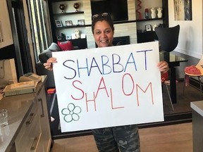 Yael Cohen holds a Good Sabbath sign. (supplied photo)