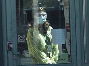 A staff member gazes out the window as the Seven Oaks Long-Term Care Home in Toronto.
