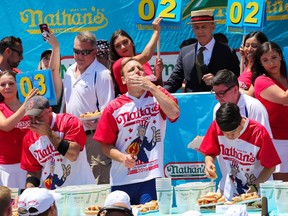 Joey Chestnut (C) eats during the men's hot dog eating contest on July 4, 2019 in New York City.