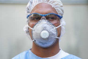 BERLIN, GERMANY - APRIL 08: Doctor's assistant Jose Perez, who is wearing a protective mask, goggles and suit, waits at the garage that the medical practice he works for is using to receive and test possible Covid-19 patients during the coronavirus crisis on April 08, 2020 in Berlin, Germany. The practice is using the garage as a venue to take throat swab samples in order to avoid having possibly infected people come into the practice and contaminate it with the coronavirus. The city of Berlin has confirmed approximately 4,000 Covid-19 infections. Doctor Beate Krupka of the practice said the number of people testing positive from her samples has been declining recently. Germany has over 100,000 confirmed cases of infection and over 1,800 people have died.  (Photo by Sean Gallup/Getty Images)