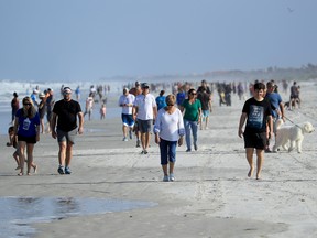 People are seen at the beach on April 17, 2020 in Jacksonville Beach, Florida. Jacksonville Mayor Lenny Curry announced Thursday that Duval County's beaches would open at 5 p.m. but only for restricted hours and can only be used for swimming, running, surfing, walking, biking, fishing, and taking care of pets.