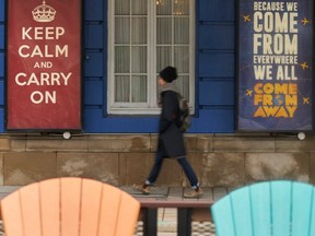 A woman walks past the Royal Alexandra Theatre in Toronto, Ontario on March 24, 2020. (AFP via Getty Images)