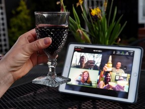 A woman lifts her glass  with friends during a virtual happy hour amid the Covid-19 crisis on April 8, 2020, in Arlington, Va.