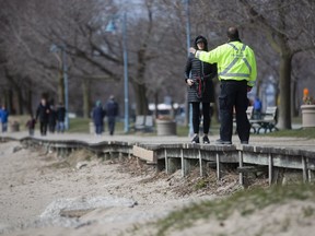 A bylaw officer enforcing social distancing rules is pictured along the eastern beaches on  April 11, 2020. (Stan Behal,Toronto Sun)