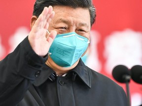 This photo released on March 10, 2020 by China's Xinhua News Agency shows Chinese President Xi Jinping wearing a mask as he waves to a coronavirus patient via a video link at the Huoshenshan hospital in Wuhan, China.
(AFP via Getty Images)