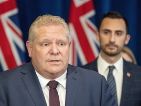 Ontario Premier Doug Ford speaks at a news conference as Education Minister Stephen Lecce listens at Queen's Park in Toronto on March 20, 2020.
