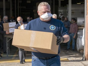 Ontario Premier Doug Ford loads ASTM Level 3 masks made by The Woodbridge Group in Woodbridge, Ont. on Tuesday, April 7, 2020. THE CANADIAN PRESS/Frank Gunn