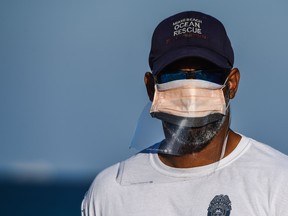 A member of the Miami Beach Ocean Rescue wears a mask screened by a homemade plastic cover as he stands guard in South Beach, Miami, amid fears over the spread of the novel coronavirus (COVID-19) on April 1, 2020. (CHANDAN KHANNA/AFP via Getty Images)