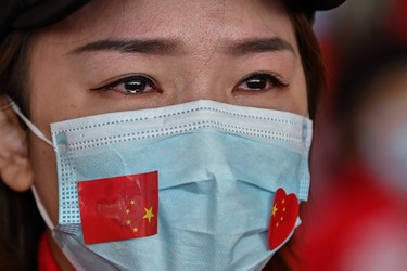 TOPSHOT - A medical staff member from Jilin Province tears up during a ceremony before leaving as Tianhe Airport is reopened in Wuhan in China's central Hubei province on April 8, 2020. - Thousands of Chinese travellers rushed to leave COVID-19 coronavirus-ravaged Wuhan on April 8 as authorities lifted a more than two-month prohibition on outbound travel from the city where the global pandemic first emerged. (Photo by Hector RETAMAL / AFP) (Photo by HECTOR RETAMAL/AFP via Getty Images)