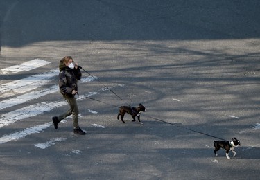 A woman wearing a face mask, amid concerns over the spread of the COVID-19 coronavirus, walks her dogs in the Ukrainian capital of Kiev on April 8, 2020. (Photo by Sergei SUPINSKY / AFP) (Photo by SERGEI SUPINSKY/AFP via Getty Images)