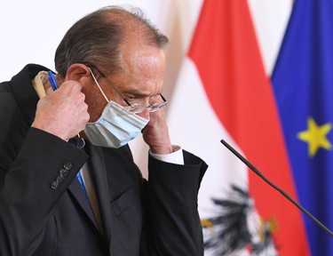 Austria's Education Minister Heinz Fassmann put on his face mask prior a press conference on schools on April 8, 2020 in Vienna, Austria. (Photo by HELMUT FOHRINGER / APA / AFP) / Austria OUT (Photo by HELMUT FOHRINGER/APA/AFP via Getty Images)