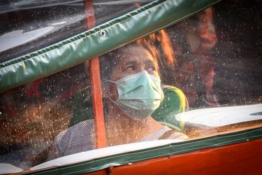 A commuter wearing a facemask to combat the spread of the COVID-19 novel coronavirus rides a canal boat in Bangkok on April 8, 2020. (Photo by Mladen ANTONOV / AFP) (Photo by MLADEN ANTONOV/AFP via Getty Images)