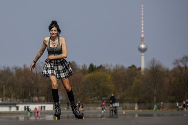 An inline skater, asked to be named as Melinartista, practices at the former airport at Tempelhofer Feld with the TV Tower in the background as the sun shines on April 8, 2020 in Berlin. (Photo by David GANNON / AFP) (Photo by DAVID GANNON/AFP via Getty Images)