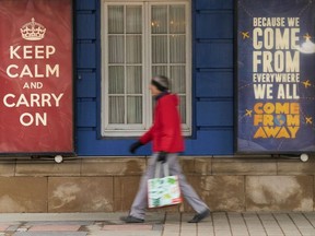 In this file photo taken on March 24, 2020, a woman walks past the Royal Alexandra Theatre in Toronto, Ontario.