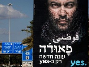 (FILES) In this file photo taken on December 31, 2017 a billboard with Arabic and Hebrew writing promoting the new season for a hit Israeli television series "Fauda" is pictured in Tel Aviv.