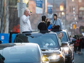 People film and cheer from their cars as Toronto first responders parade down hospital row in Toronto, Ontario, Canada, in a salute to healthcare workers on April 19, 2020.