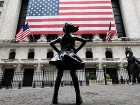 The fearless girl statue and the New York Stock Exchange (NYSE) are pictured on April 20, 2020 at Wall Street in New York City. - Wall Street opened lower on Monday as traders grappled with a drop in oil prices to 22-year lows as the coronavirus pandemic sapped demand for energy. The Dow Jones Industrial Average was down 1.8 percent to 23,798.01 about 10 minutes into the trading session.The broad-based S&P 500 had declined 1.3 percent to 2,835.08, while the tech-rich Nasdaq had fallen 0.7 percent to 8,588.66. (Photo by Johannes EISELE / AFP) (Photo by JOHANNES EISELE/AFP via Getty Images)