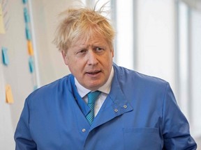 In this file photo taken on March 6, 2020, Britain's Prime Minister Boris Johnson visits the Mologic Laboratory in the Bedford Technology Park, north of London.