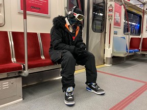 A man wearing ski goggles, gloves and clothing rides the subway during the global outbreak of coronavirus disease (COVID-19) in Toronto, Ontario, Canada March 31, 2020.