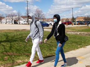 Two people walk by the Etobicoke General Hospital drive-thru COVID-19 assessment centre as the number of coronavirus disease (COVID-19) cases continue to grow, in Toronto, Ontario, Canada April 9, 2020. REUTERS/Carlos Osorio ORG XMIT: GGGCAN106