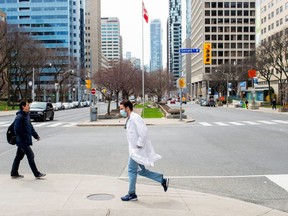 A health care worker runs across University Avenue from Mount Sinai Hospital to Toronto General Hospital as the number of the coronavirus disease (COVID-19) cases continues to grow in Toronto, Ontario, Canada April 17, 2020.