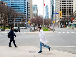 A healthcare worker runs across University Ave. from Mount Sinai Hospital to Toronto General Hospital.