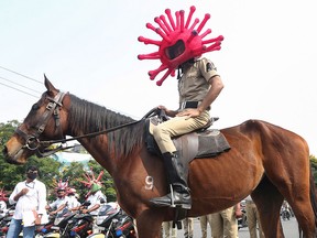 An Indian policeman wearing a virus themed helmet rides on a horse during an awareness rally aimed at preventing the spread of new coronavirus in Hyderabad, India, Thursday, April 2, 2020.