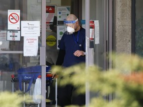 A man exits Eatonville Care Centre on The East Mall in Toronto with a Life Labs specimen bag on Tuesday, April 14, 2020.