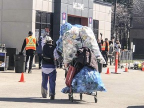 Bringing back a big haul of empties to the sorting stations outside The Beer Store on Danforth Ave., east of Victoria Pk. Ave., in Scarborough on Saturday, April 25, 2020.