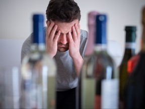 Depressed man drinking hard liquor at home