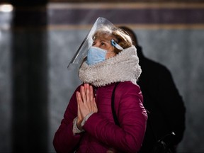 A woman with a mask and protective helmet prays during the Palm Sunday service in the golden doomed Alexander Nevski cathedral in Sofia on April 12, 2020, amid the coronavirus disease (COVID-19) outbreak. - Bulgaria, a predominantly Christian Orthodox country, celebrates Palm Sunday on April 12 and Easter on April 19 when huge crowds traditionally gather in and around churches for vigils and services even if regular churchgoers are much less numerous.The church's governing body the Holy Synod has insisted that cathedrals and churches would remain open, despite persistent calls from medical experts and the government's coronavirus taskforce to shut their doors to believers to prevent a potential boom in infections with the novel coronavirus. (Photo by NIKOLAY DOYCHINOV / AFP) (Photo by NIKOLAY DOYCHINOV/AFP via Getty Images)