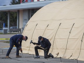 Masked GlobalMedic volunteers set up a "critical infrastructure tent" in a parking lot at Brampton Civic Hospital on Saturday, April 4, 2020. The tent could be used to triage emergency room patients or for testing those who believe they have COVID-19.