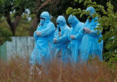 Relatives wearing protective gear offer funeral prayers for a woman who died due to the coronavirus disease (COVID-19), at a graveyard in Chennai, India, April 8, 2020. REUTERS/P. Ravikumar ORG XMIT: PPP-DEL08