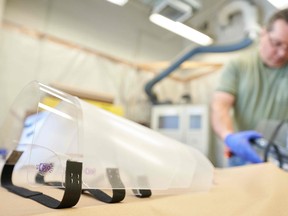 The Health Canada approval sticker is seen on completed faces shields for health care workers as machinist Steve Arnold works on more at University Machine Services in the Faculty of Engineering at Western University in London, Ont., on April 6, 2020. (GETTY IMAGES)